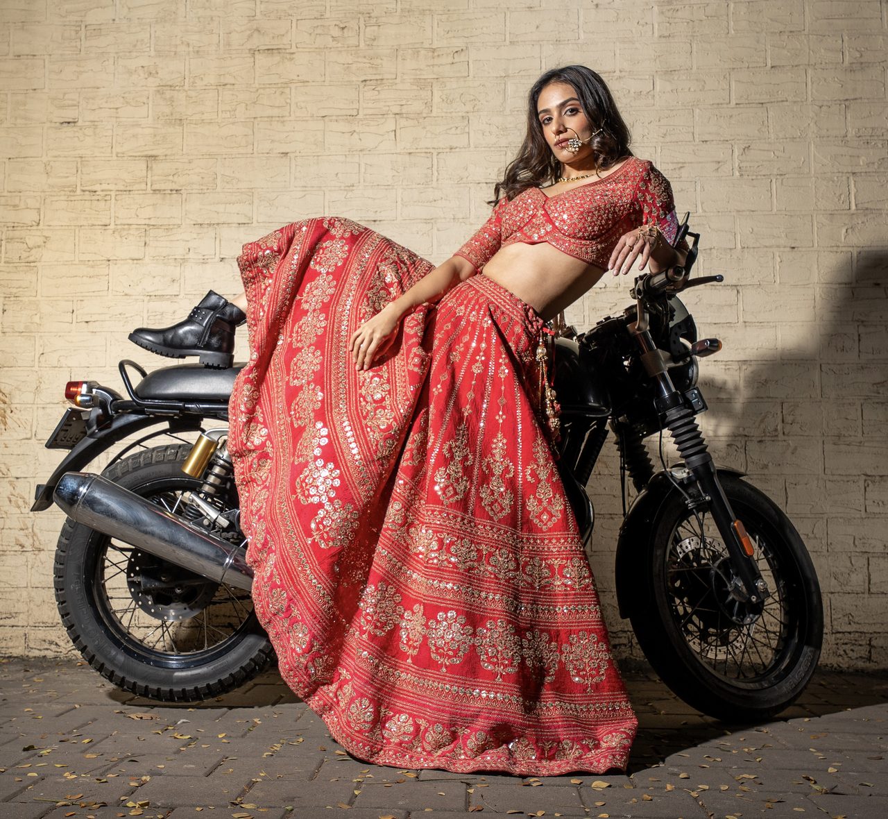 Siffaat Gandhi — red lehenga at a motorcycle, Mumbai brick wall