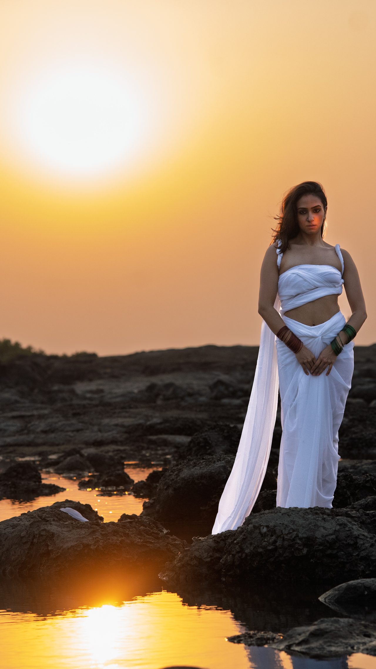 Siffaat Gandhi — still figure, dusk sun and tidepool