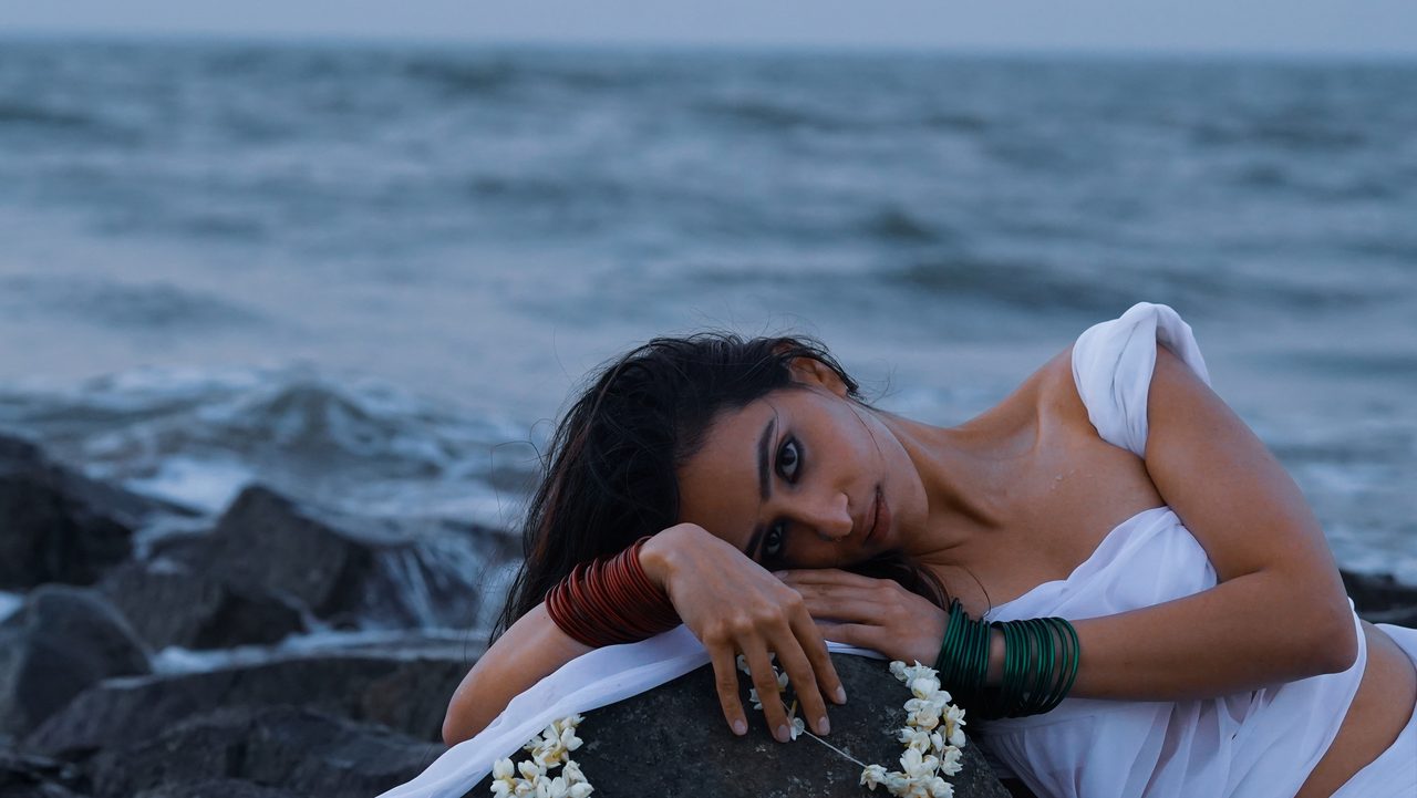 Siffaat Gandhi — resting on tide rocks, ocean behind